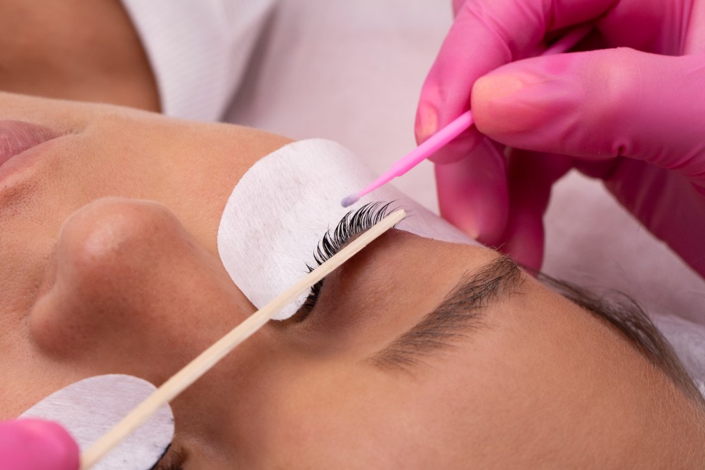 high-angle-hand-holding-pink-swab